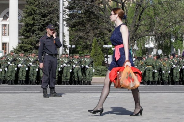 Жена минава покрай военнослужещите на самопровъзгласената народна република Донецк, която участва в репетиция за парада &quot;Ден на победата&quot; в Донецк, Украйна. Снимка: Reuters