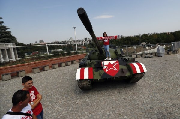 Футболна фенка се снима върху Танк T-55, разположен до стадион &quot;Райко Митич&quot; в Белград, където играе местният футболен гранд Цървена звезда. Сръбският шампион излиза тази вечер в решителен мач реванш срещу швейцарския Йънг Бойс в борба за влизане в групите на Шампионската лига. Снимка: БТА