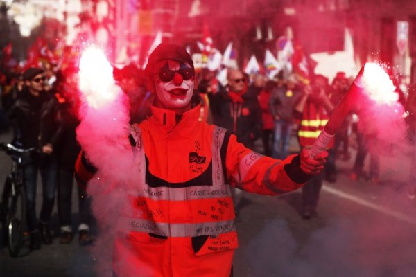 Протестиращ държи запалени факли по време на протест срещу пенсионната реформа в Марсилия. Снимка: БГНЕС