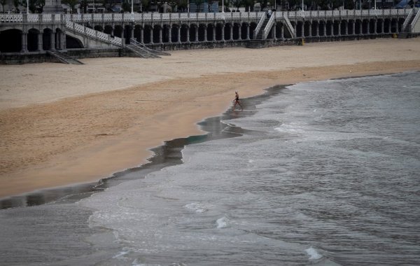 Жена излиза от водата след сутрешно плуване в морето край испанския град Сан Себастиан. Снимка: БГНЕС