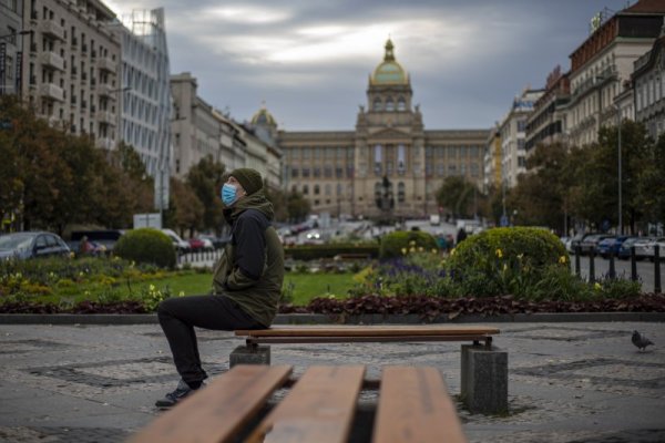 Мъж с маска на лицето стои на пейка в централната част на Прага. Заради многото случаи на коронавирус в последните дни чешкото правителство въведе от днес още по-тежки мерки в страната. Снимка: БГНЕС