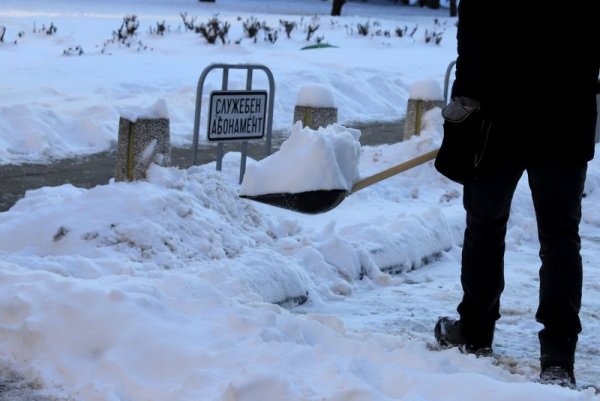 Мъж почиства тротоар в студената понеделнишка утрин в София. Снимка: БГНЕС