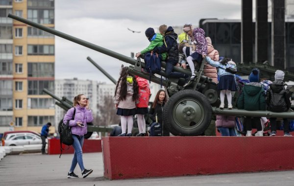 Деца се катерят върху старо оръжие от Втората световна война, разположено на улица в Москва. Снимка: БГНЕС