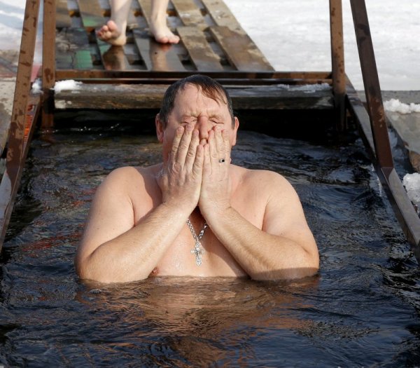 Мъж се къпе в ледена вода за здраве по повод Богоявление в Киргистан. Снимка: БГНЕС